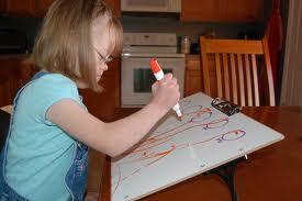 young girl using slant board at home schooling desk