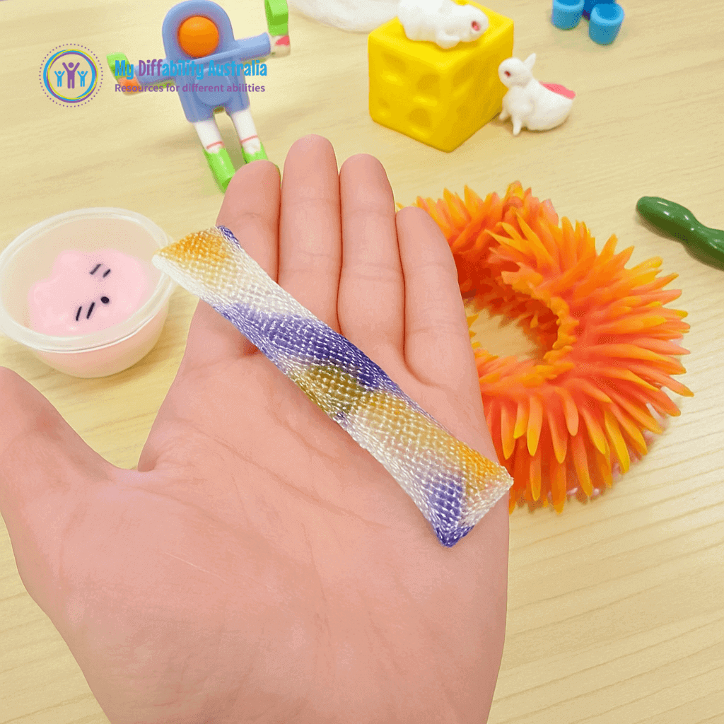 Multi coloured Marble Mesh Fidget Toy Placed In Ones Palm While Other Fidget Toy Is in the background