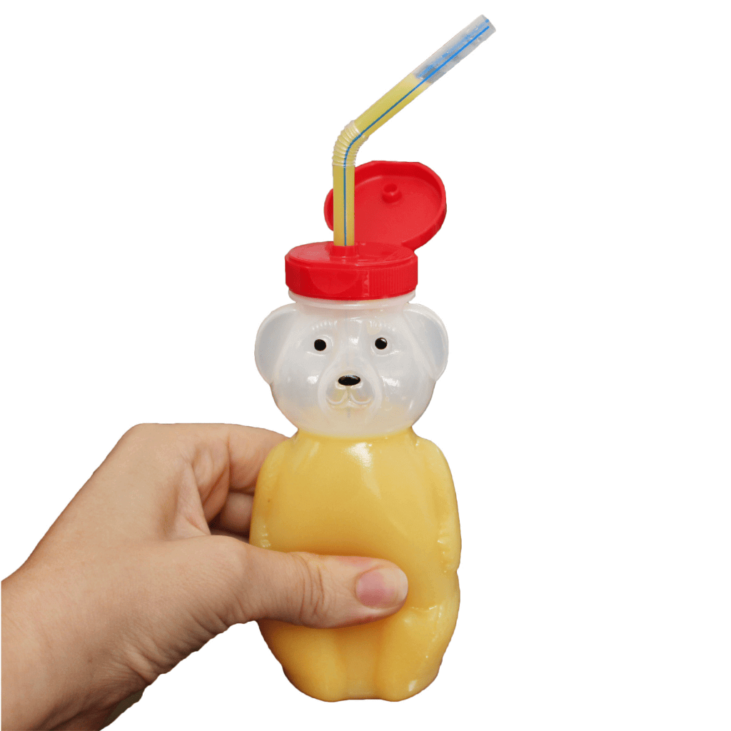 One Hand Holding Honey Bear Bottle that has liquid inside it