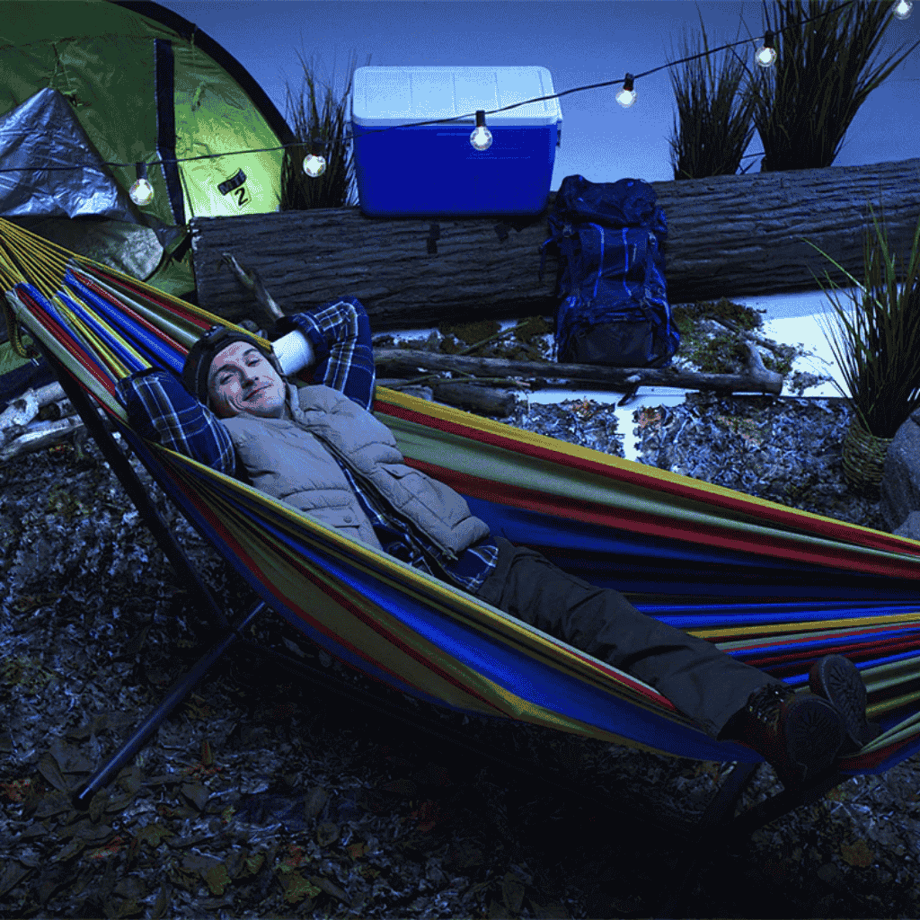 Picture of a man campting while laying in the Double Hammock with Stand