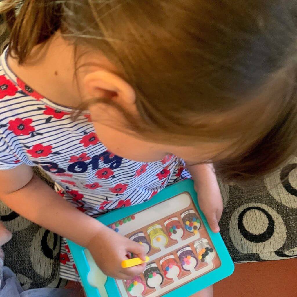 Picture of a young girl holding Colour Number Maze Magnetic Pad Magnetic Colour Sorting Maze