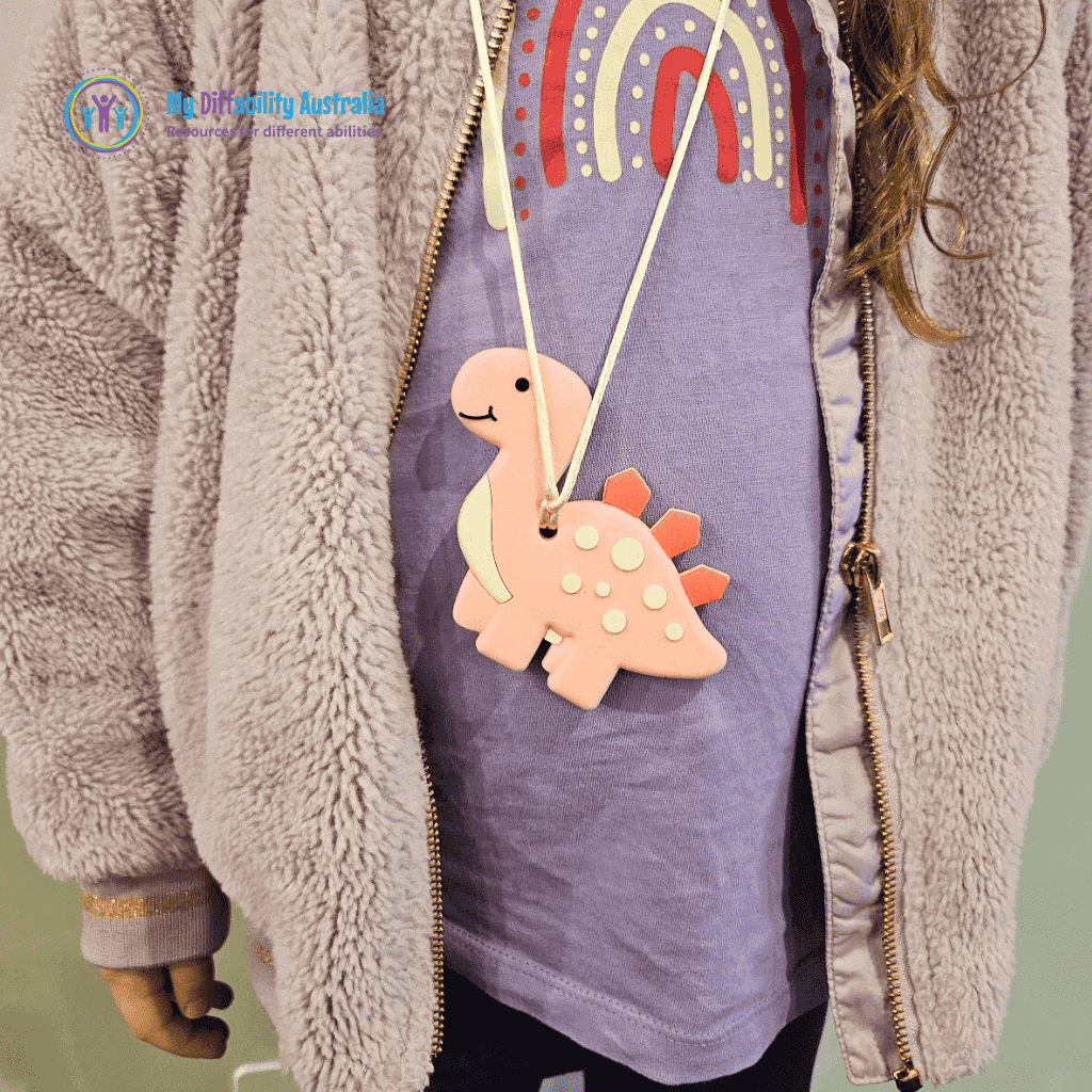Pink Dinosaur Chewy Pendant Worn By A Kid