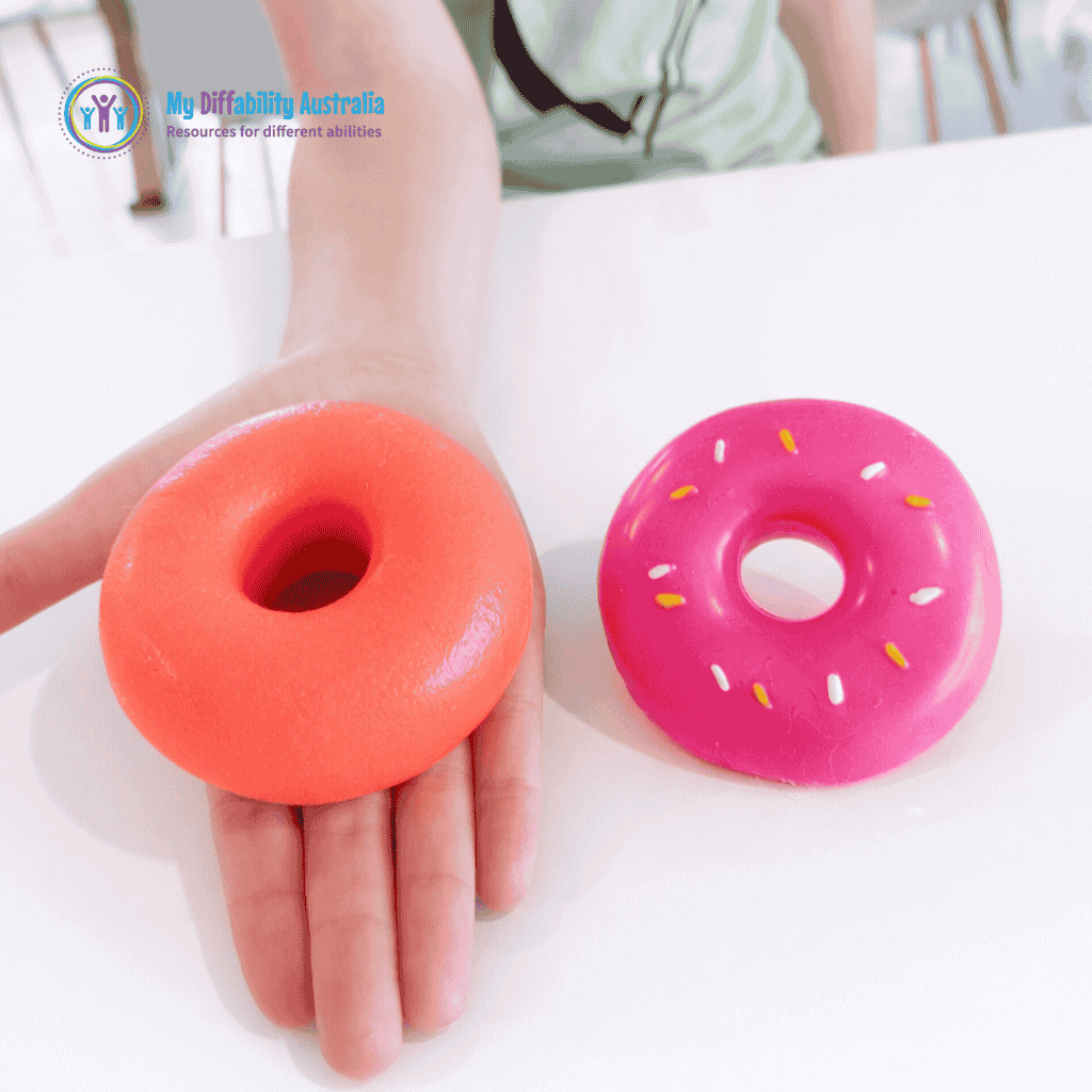 Two NeeDoh Dohnut One In the palm the other in the table