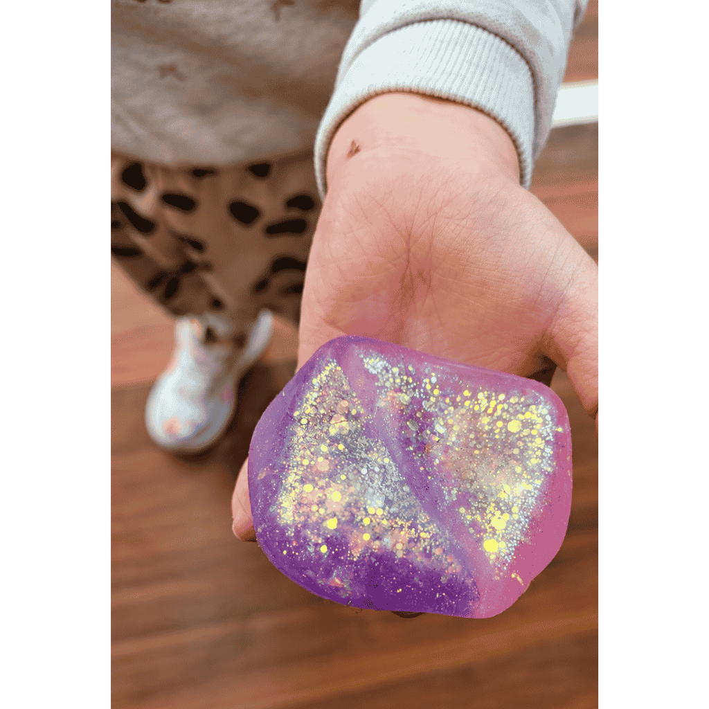 Two Tone Glitter Squeezy Cube placed in a kids palm