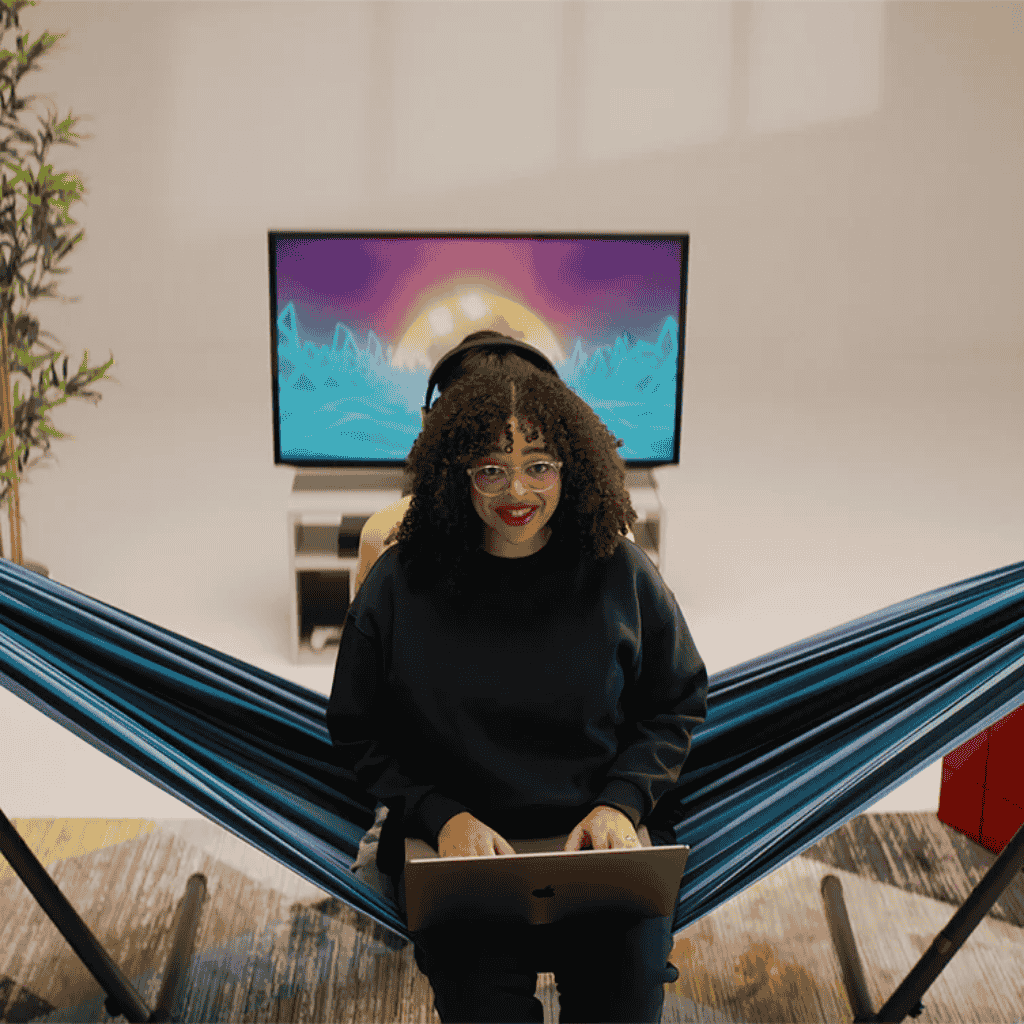 Woman working in her laptop while seating in the Double Hammock with Stand