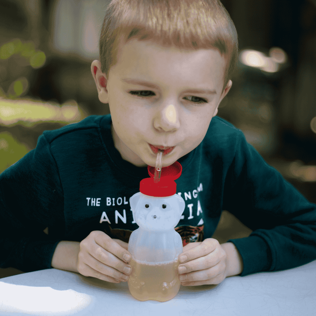 Young Boy Shown Sipping from the Honey Bear Bottle