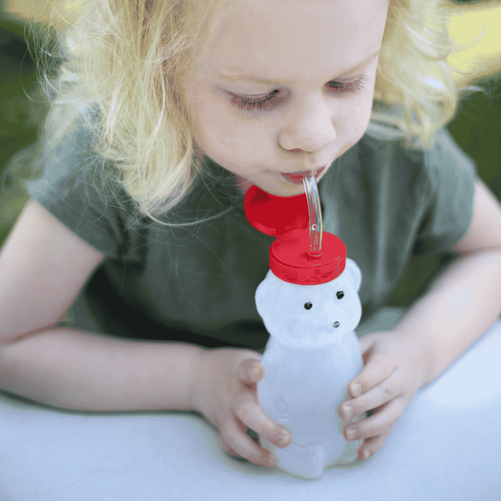 Young Girl Shown Sipping Water from the Honey Bear Bottle