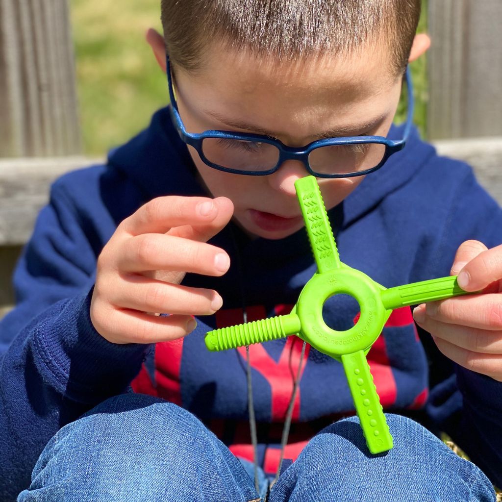 Young boy holding ark tetra bite chewy fidget