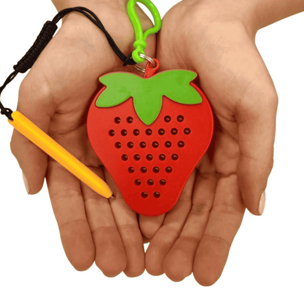 Hands holding Strawberry Magnetic Pad Keyring