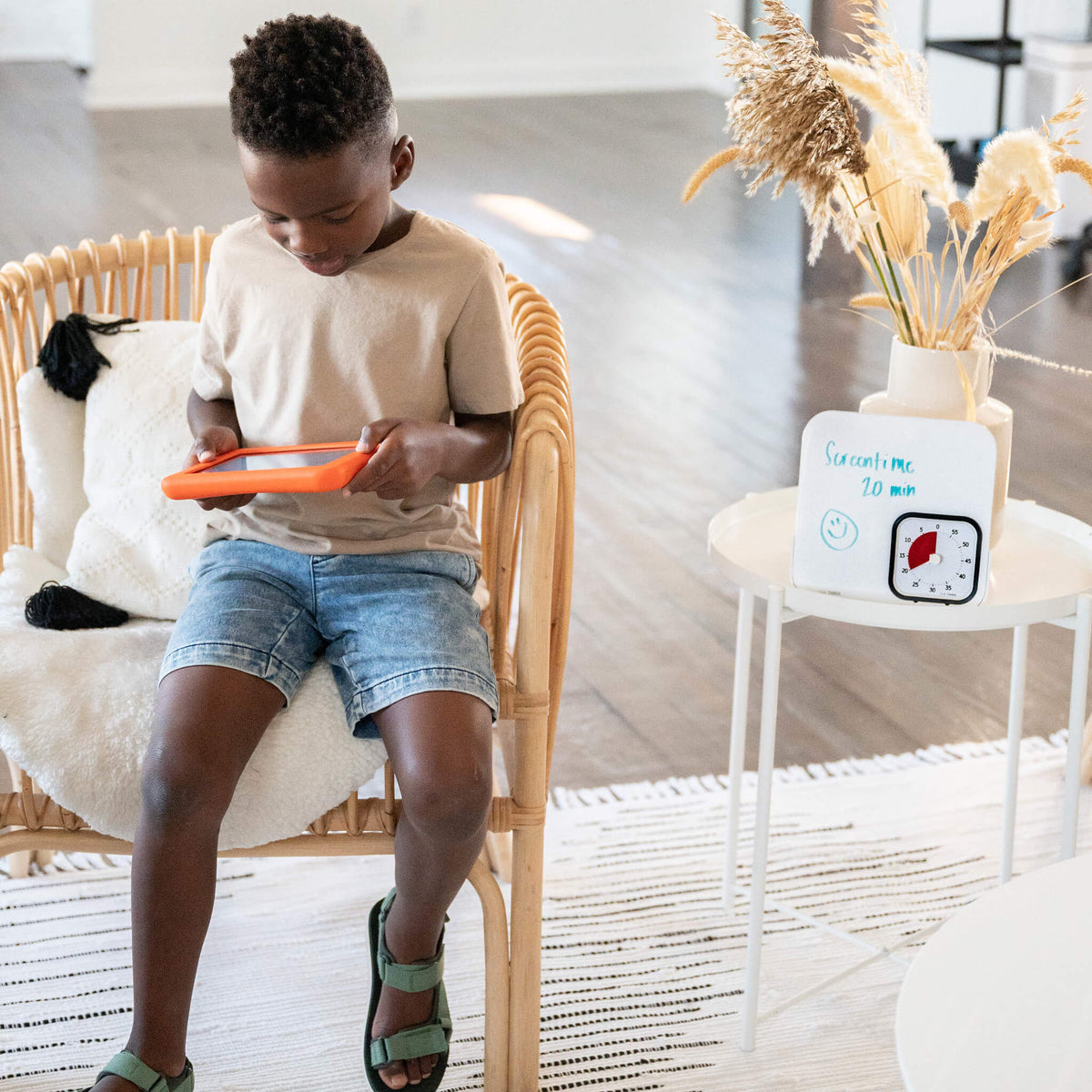 kid playing ipad while time timer mod with dry eraser board is in the side