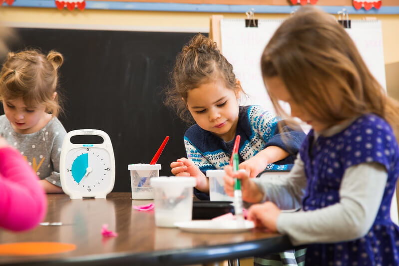 kid doing art work while using time timer 20 minute with pause feature