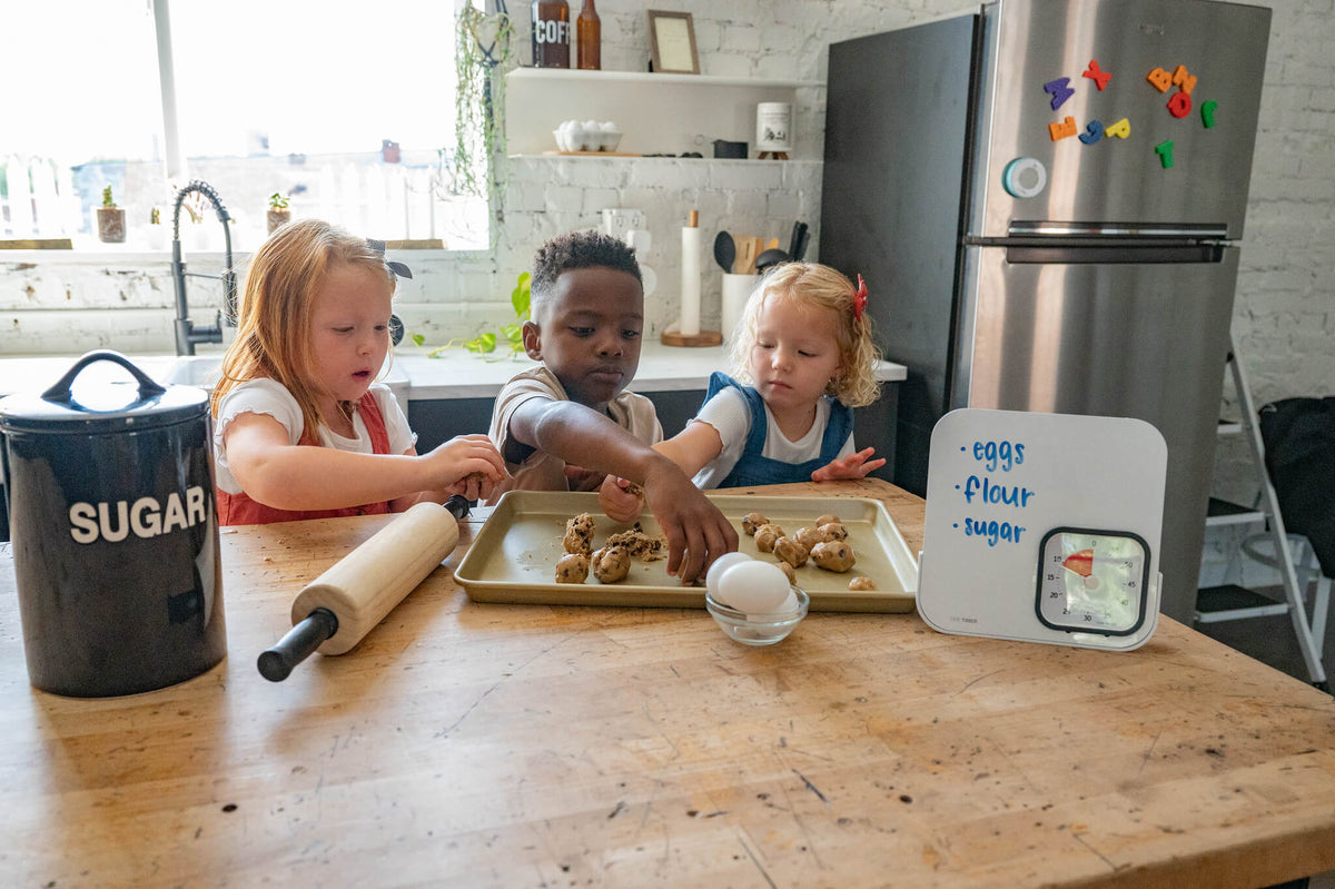 kids trying to bake cookies while time timer is in the side