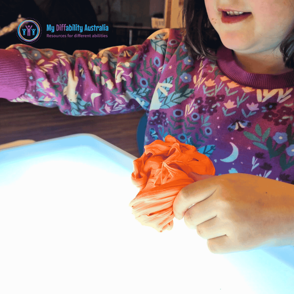orange putty placed on top of messy play light box
