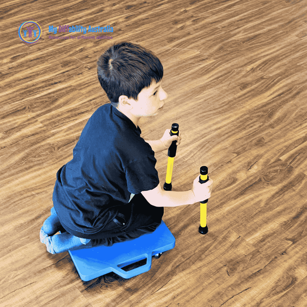 young boy seating in the scooter board blue while holding yellow scooter paddles