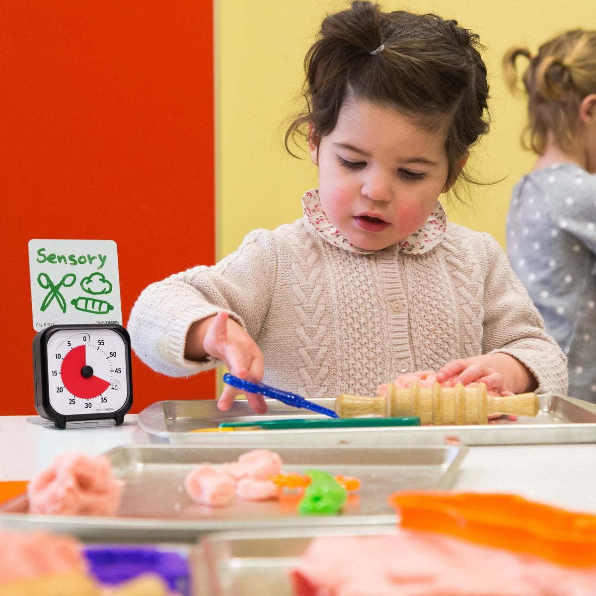 Young child in a classroom using Time Timer Original 3 Visual Support during play.