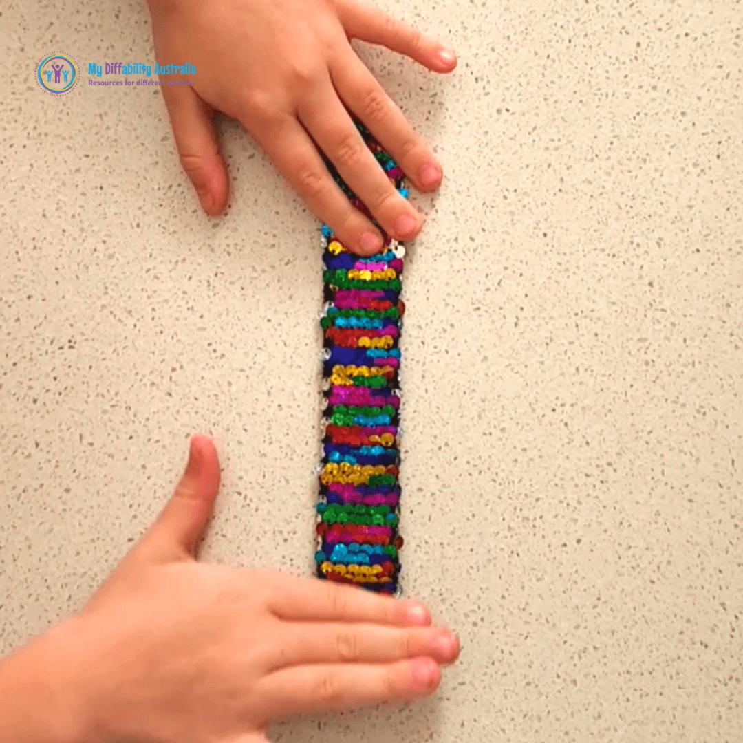 https://www.mydiffability.com.au/cdn/shop/products/Zoom-In-Sequin-Sensory-Slap-Band_1200x.png?v=1666227197