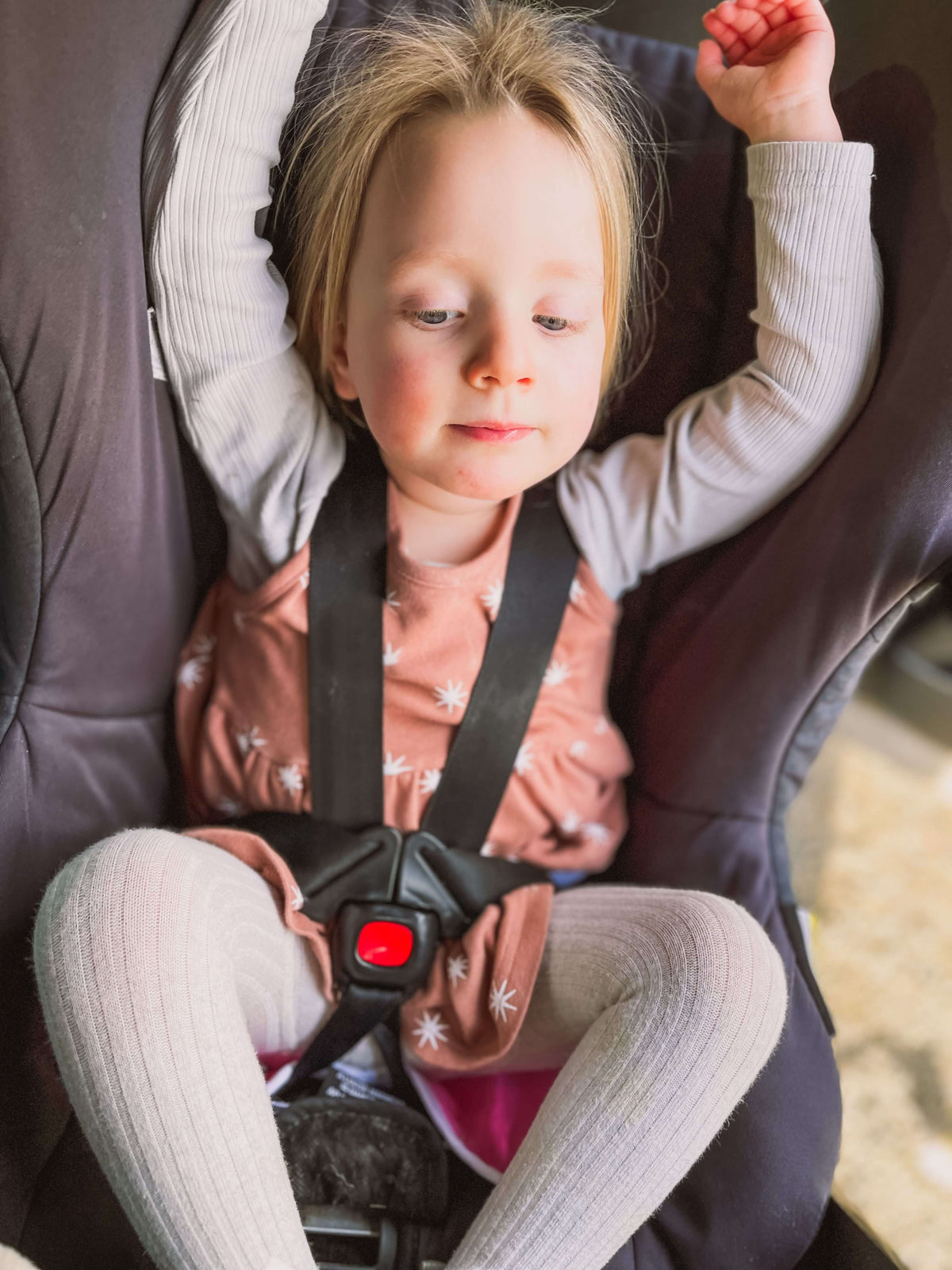 kid seating on a car seat with protector