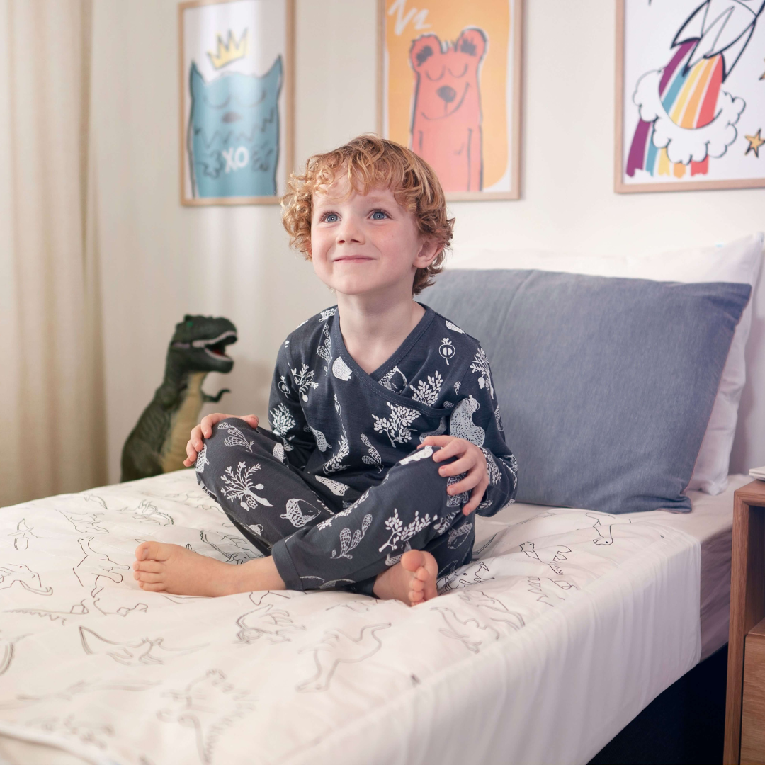 kids seating on a brolly sheet dinosaur